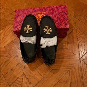 Tory Burch Black Slip-Ons with Gold Emblem